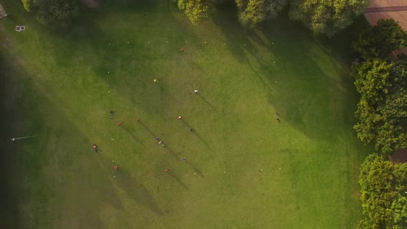 Birds eye drone shot of Green Point Park in Cape Town - drone is ascending over athletes playing foo