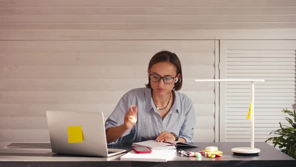 Woman Writing Notes Talking on Cellphone Remote Work From Home Office During Covid Lockdown