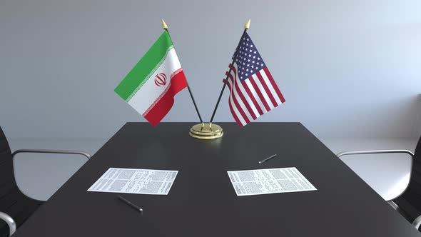 Flags of Iran and the United States and Papers on the Table