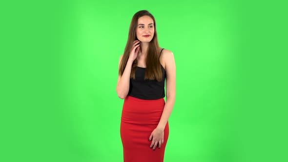 Young Woman Stands Waiting on Green Screen