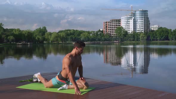 Relaxed Handsome Man Physical Exercises for Legs Near Lake