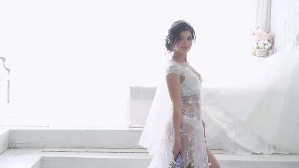 Slow Motion Wonderful Woman Stands Against Wedding Dress