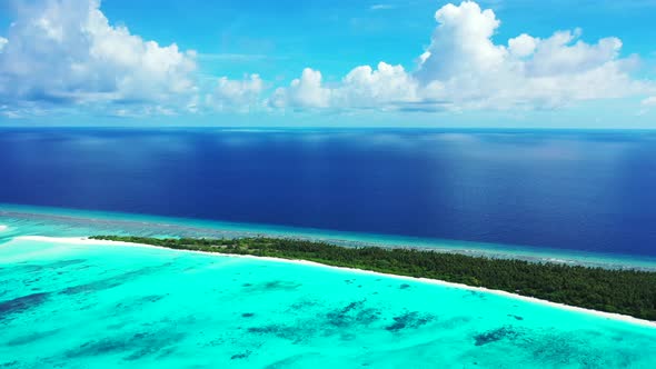 Daytime overhead copy space shot of a white sandy paradise beach and aqua blue water background in 4