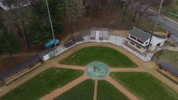 Aerial view of empty ball field in autumn. Residential neighborhood surrounding.