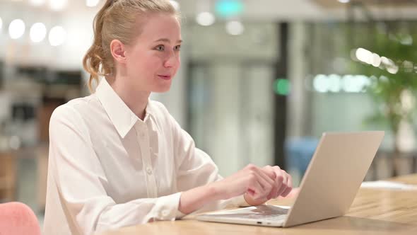 Cheerful Young Businesswoman Doing Video Chat on Laptop