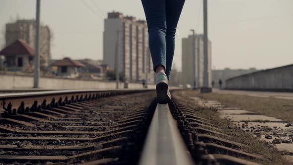 Girl Walks To Home On Railroad Tracks After Canceled Tram Public Transport. Woman Feet In Jeans
