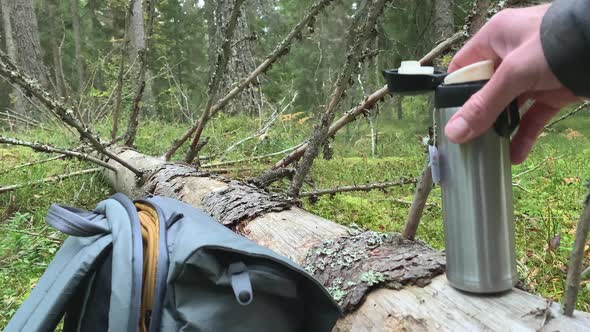 Amazing Shot of a Fallen Dried Spruce and a Thermos and a Hiking Bag