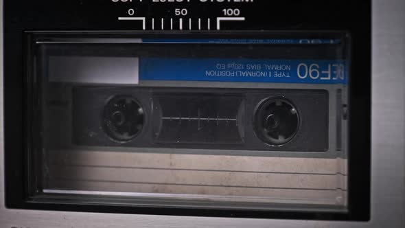 Audio Cassette Tape Rotates in Deck of an Old Tape Recorder