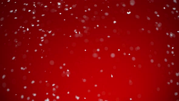 Super Slow Motion Shot of Real Snow Falling on Red Background at 1000 Fps