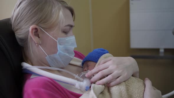 Woman Holds Newborn Baby with Tubes
