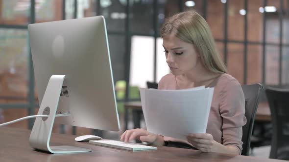 Attractive Woman Working on Document and Computer