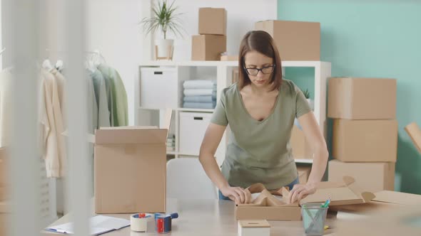 Saleswoman Wrapping Piece of Clothes for Sending