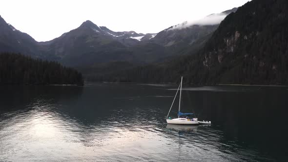 Reflections Through Serene Crystal Lake Water With Ship Floating Surrounded By Snow Mountains During