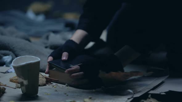 Homeless Person Reading Bible Lying on Ground, Praying for Better Life, Poverty