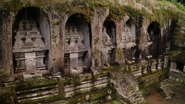 Shrines cut into cliff niches at historic Kawi Sebatu temple in Ubud; drone