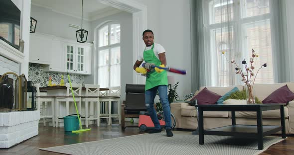 Worker of Cleaning Service Having Fun while Cleaning up Customer House Using Vacuum Cleaner