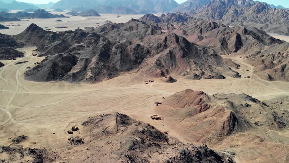 Top view of the Sahara desert, desert mountains. Wooden Bedouin houses. Sands.