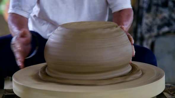 Closeup Potter Man Grinds Big Ceramic Vessel with Metal Ring