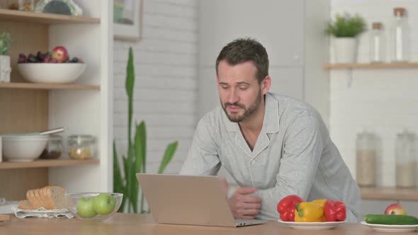 Young Man Doing Video Call on Laptop in Kitchen