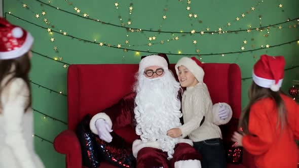 Santa Claus gives presents to small children. Christmas holiday