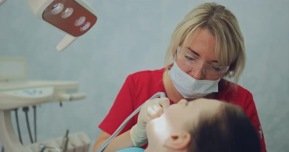 Dentist Doctor Drills a Tooth to a Patient