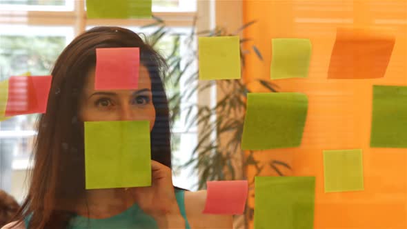 Female executive reading sticky notes