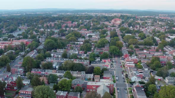 American urban city. Descending aerial at night. Evening shot at summer. Neighborhood homes and down