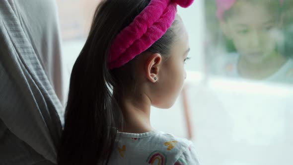 Cheerful Asian girl looking at window in room