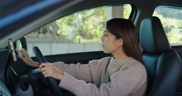Woman drive a car and use of mobile phone for gps location