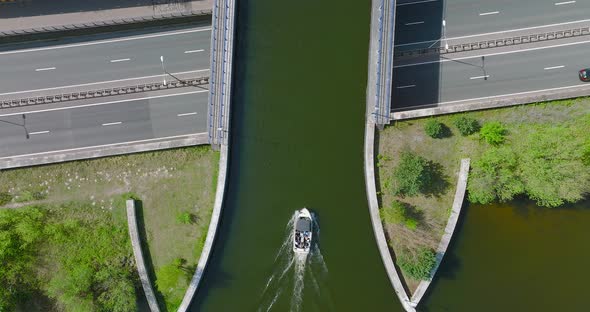 Aquaduct Veluwemeer water bridge with boat crossing above highway traffic, Aerial view.