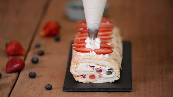 Process of making meringue roulade with summer berries