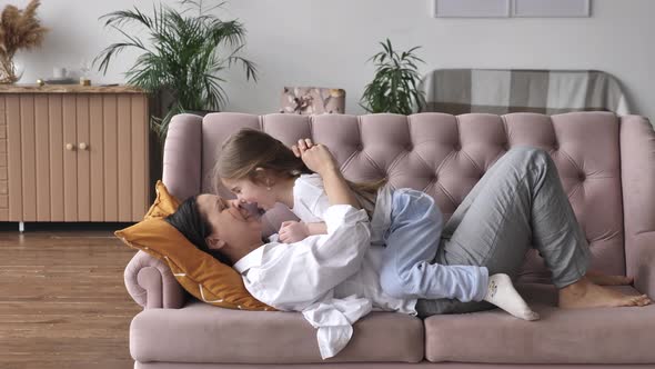 Happy Family Young Mom Playing with Kid Girl on Sofa at Home Mother Tickle Child