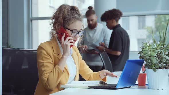 Woman Working in Office and Talking on Phone