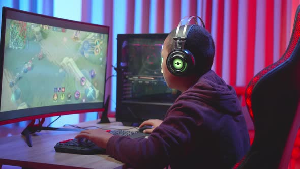 Young Boy Wearing Headphones Serious Playing Video Game