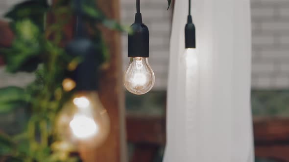 Edison light bulb hangs on ceiling in spacious restaurant
