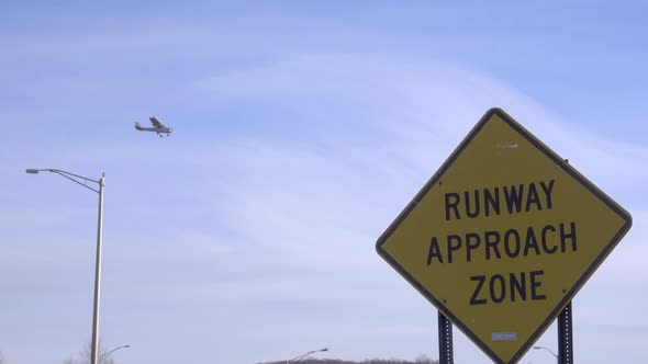 Plane Lands Near an Airport Approach Warning Sign