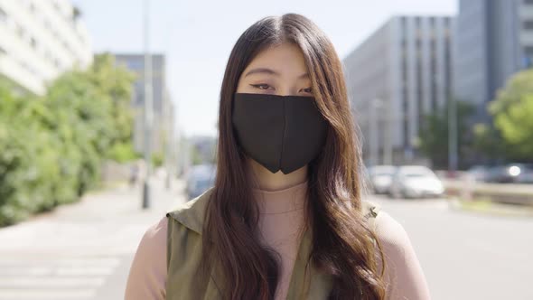 Young Asian Woman Face Mask Looks Camera Street Urban Area  Closeup
