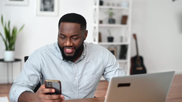 AfricanAmerican Guy Is Typing on Smartphone