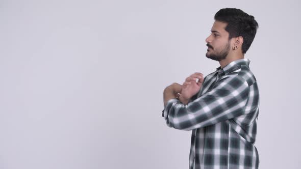 Profile View of Young Handsome Bearded Indian Man Looking at Camera