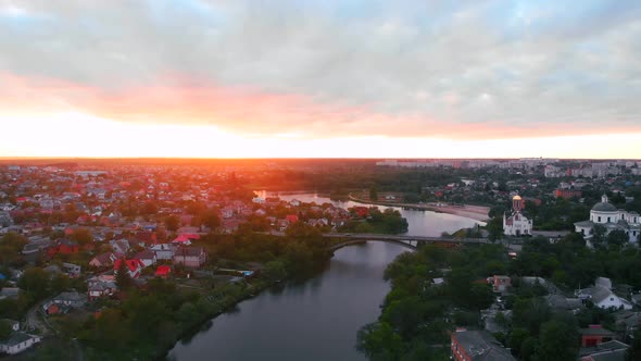 Drone Fly Above River in Beautiful Small European City During Sunset in Spring