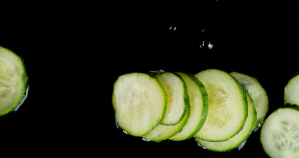 Round Slices of Fresh Cucumber Roll on the Water. 