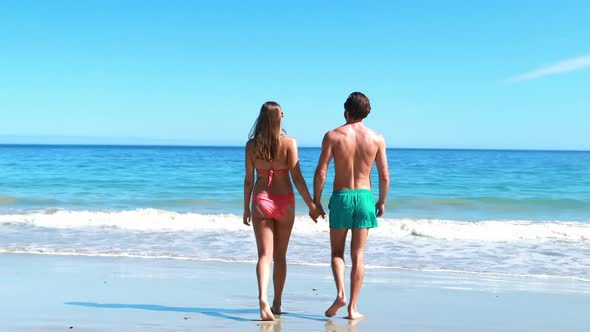 Rear view of couple walking on beach