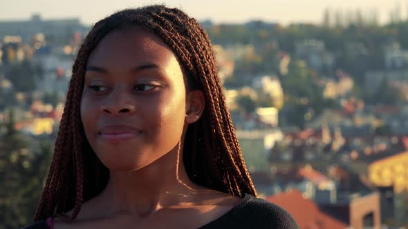 Young Beautiful Black Woman Smiles To Camera - City in the Background - Closeup