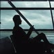 Silhouette of Man Listening To Music on Smartphone in Airport - VideoHive Item for Sale