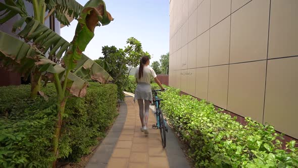 Woman Walks with a Bicycle