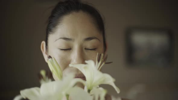 Woman smelling lilies