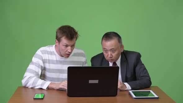 Mature Japanese Businessman and Young Scandinavian Businessman Working Together