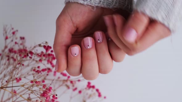 Woman Showing Hands with Beautiful Nude Manicure Holding Delicate Pink Gypsophila or Baby's Breath