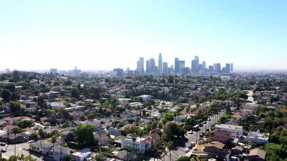 Beautiful drone shot flying high above neighborhoods of Los Angeles, California showing the city sky
