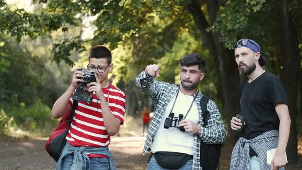 Group of Friends Hikers Standing in the Forest and Looking for Places